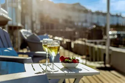 a table with two glasses of wine and a bowl of flowers at 3 Bed in Porthleven oc-1seav in Porthleven