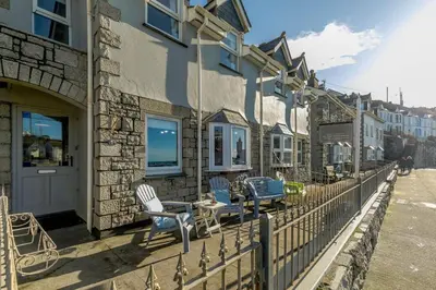 a balcony with chairs and a table on a building at 3 Bed in Porthleven oc-1seav in Porthleven