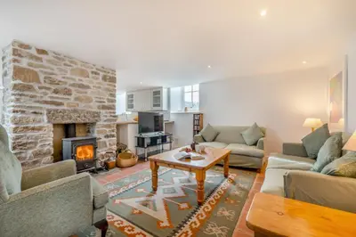 a living room with a stone fireplace and a table at 2 Bed in Rinsey oc-2chapl in Praa Sands