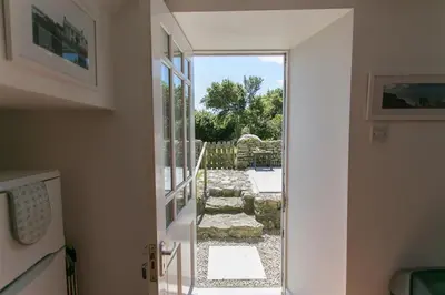 an open door to a yard with a stone pathway at 2 Bed in Rinsey oc-2chapl in Praa Sands