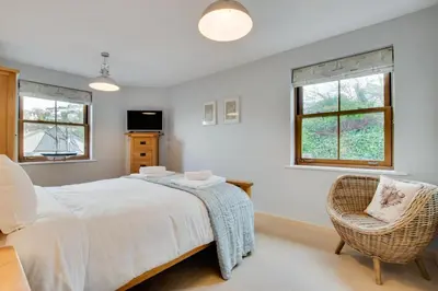 a bedroom with a bed and a chair and windows at 2 Bed in Looe oc-6creek in Looe