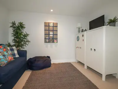 a living room with a blue couch and a tv at 5 Longshore in Newquay