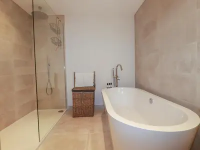 a bathroom with a white tub and a glass shower at 5 Longshore in Newquay