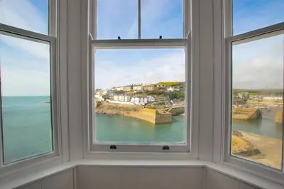 a room with three windows looking out at the ocean at 3 Bed in Porthleven oc-7bayvi in Porthleven