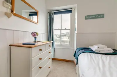 a bedroom with a bed and a dresser and a window at 3 Bed in Porthleven oc-7bayvi in Porthleven