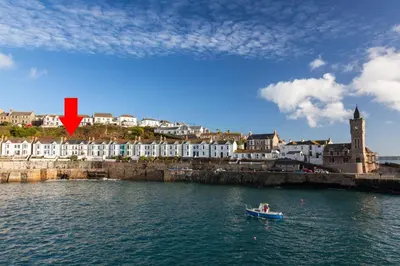 a small boat in the water near a city at 3 Bed in Porthleven oc-7bayvi in Porthleven