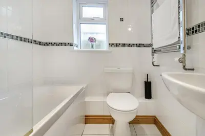 a white bathroom with a toilet and a sink at 3 Bed in Porthleven oc-atlant in Porthleven