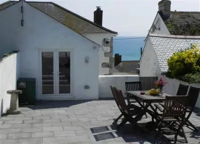 a patio with a table and chairs in front of a house at 3 Bed in Porthleven oc-atlant in Porthleven