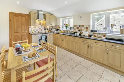 a kitchen with a table and a dining room at 3 Bed in Porthleven oc-atlant in Porthleven