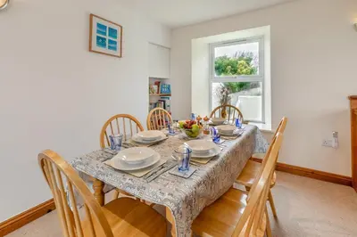 a dining room with a table and chairs at 3 Bed in Porthleven oc-atlant in Porthleven