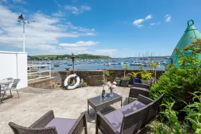 a patio with a table and chairs and a marina at 3 Bed in Falmouth oc-anchge in Falmouth