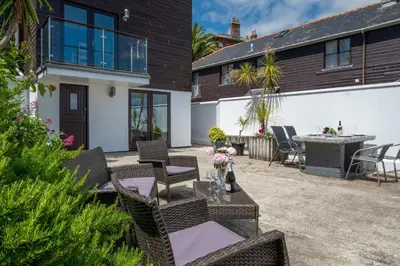 a patio with a table and chairs and a house at 3 Bed in Falmouth oc-anchge in Falmouth