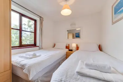 two twin beds in a room with a window at 3 Bed in Falmouth oc-anchge in Falmouth