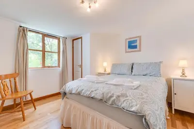 a bedroom with a bed and a chair and a window at 3 Bed in Falmouth oc-anchge in Falmouth