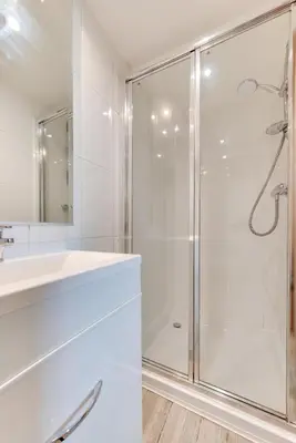 a white bathroom with a shower and a sink at 3 Bed in Falmouth oc-anchge in Falmouth