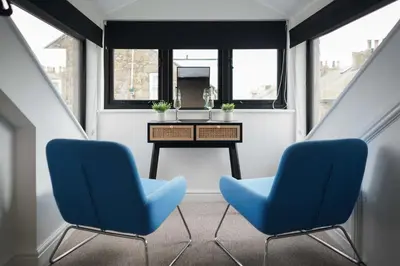 two blue chairs in a room with a table at Burrow Cottage in St Ives