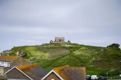 a building on top of a hill with a house at Burrow Cottage in St Ives
