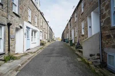 an empty street in an alley between brick buildings at Little Burrows in St Ives