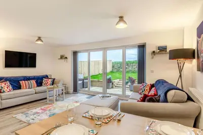 a living room with a couch and a table at 3 Bed in Penrose oc-butcup in Saint Ervan