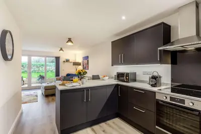 a kitchen with black cabinets and a living room at 3 Bed in Penrose oc-butcup in Saint Ervan