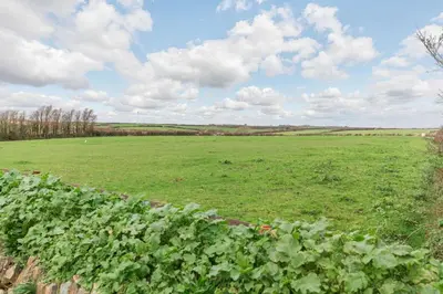 a field of green crops with a cloudy sky at 3 Bed in Penrose oc-butcup in Saint Ervan
