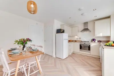 a kitchen with a table and a white refrigerator at 2 Bed in St. Eval oc-boaths in Saint Ervan