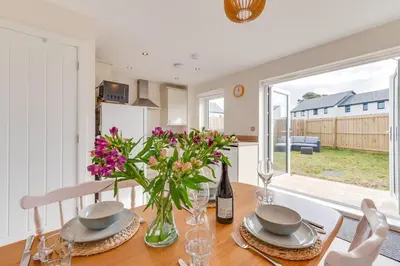 a dining room with a table with a vase of flowers at 2 Bed in St. Eval oc-boaths in Saint Ervan