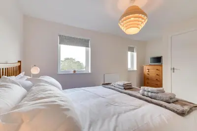 a bedroom with a large white bed with towels on it at 2 Bed in St. Eval oc-boaths in Saint Ervan
