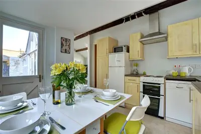 a kitchen with a table with a vase of flowers at 2 Bed in Fowey oc-ccgree in Fowey