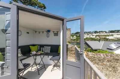 a room with a balcony with a table and a couch at 2 Bed in Fowey oc-ccgree in Fowey