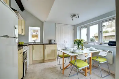 a kitchen with a table and chairs in a kitchen at 2 Bed in Fowey oc-ccgree in Fowey