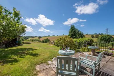 a patio with two chairs and a table in a yard at 1 Bed in Trehunist oc-chretr in Quethiock
