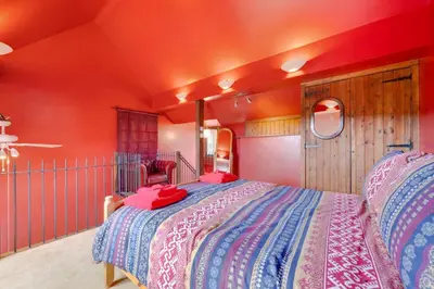 a bedroom with a large bed with red walls at 1 Bed in Trehunist oc-chretr in Quethiock
