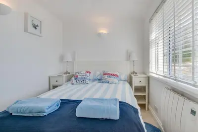 a bedroom with a bed with blue sheets and pillows at 2 Bed in Porthleven oc-clifto in Porthleven