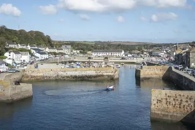 a boat in a river with a town in the background at 2 Bed in Porthleven oc-clifto in Porthleven