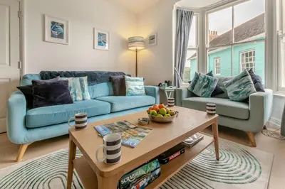 a living room with two blue couches and a table at 4 Bed in Fowey oc-chview in Fowey