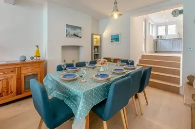 a dining room with a table and blue chairs at 4 Bed in Fowey oc-chview in Fowey