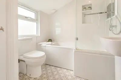 a white bathroom with a toilet and a sink at 4 Bed in Fowey oc-chview in Fowey