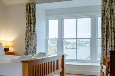 a bedroom with a bed and a large window at 5 Bed in Polruan oc-ccmead in Fowey