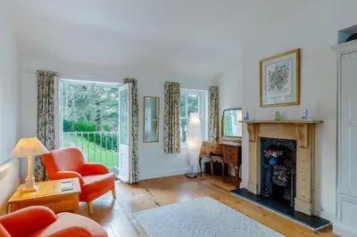 a living room with a fireplace and a piano at 5 Bed in Polruan oc-ccmead in Fowey