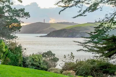 a view of a body of water with a lighthouse at 5 Bed in Polruan oc-ccmead in Fowey