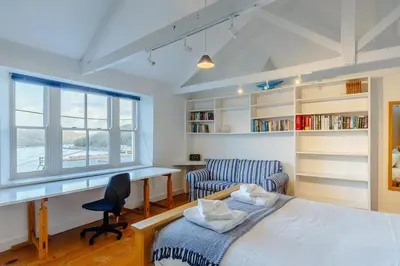 a bedroom with a bed and a desk and a chair at 5 Bed in Polruan oc-ccmead in Fowey