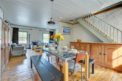 a living room with a table and a staircase at 2 Bed in Fowey oc-ccoun2 in Fowey