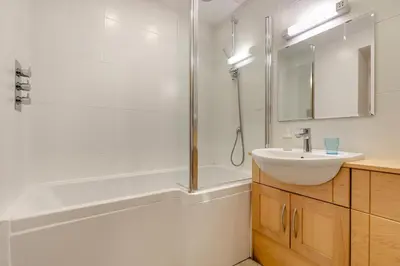 a white bathroom with a sink and a shower at 2 Bed in Polruan oc-cgart2 in Fowey