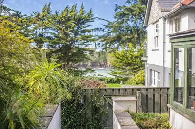 a house with a fence and a view of a river at 2 Bed in Polruan oc-cgart2 in Fowey