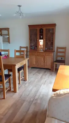 a living room with a wooden table and a cabinet at Cosy 3 Bedroom House on Cornish estate with pool in Bodmin