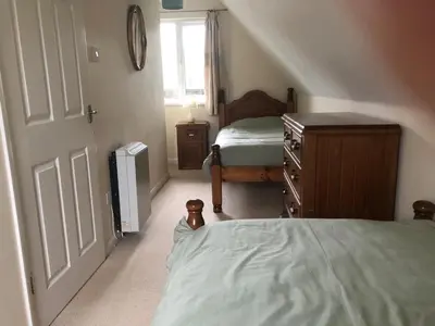 a bedroom with two beds and a dresser and a window at Cosy 3 Bedroom House on Cornish estate with pool in Bodmin