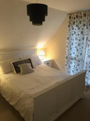 a bedroom with a large white bed and a window at Cosy 3 Bedroom House on Cornish estate with pool in Bodmin