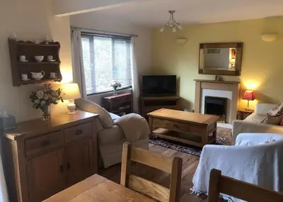 a living room with a couch and a table at Cosy 3 Bedroom House on Cornish estate with pool in Bodmin