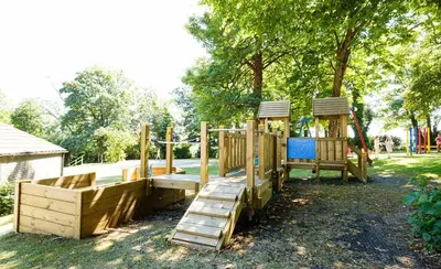 a park with a wooden playground with a slide at Cornwall family friendly villa with free use of Pool, soft play, mini golf, tennis, gym, fitness classes, sauna and ice baths in Newquay